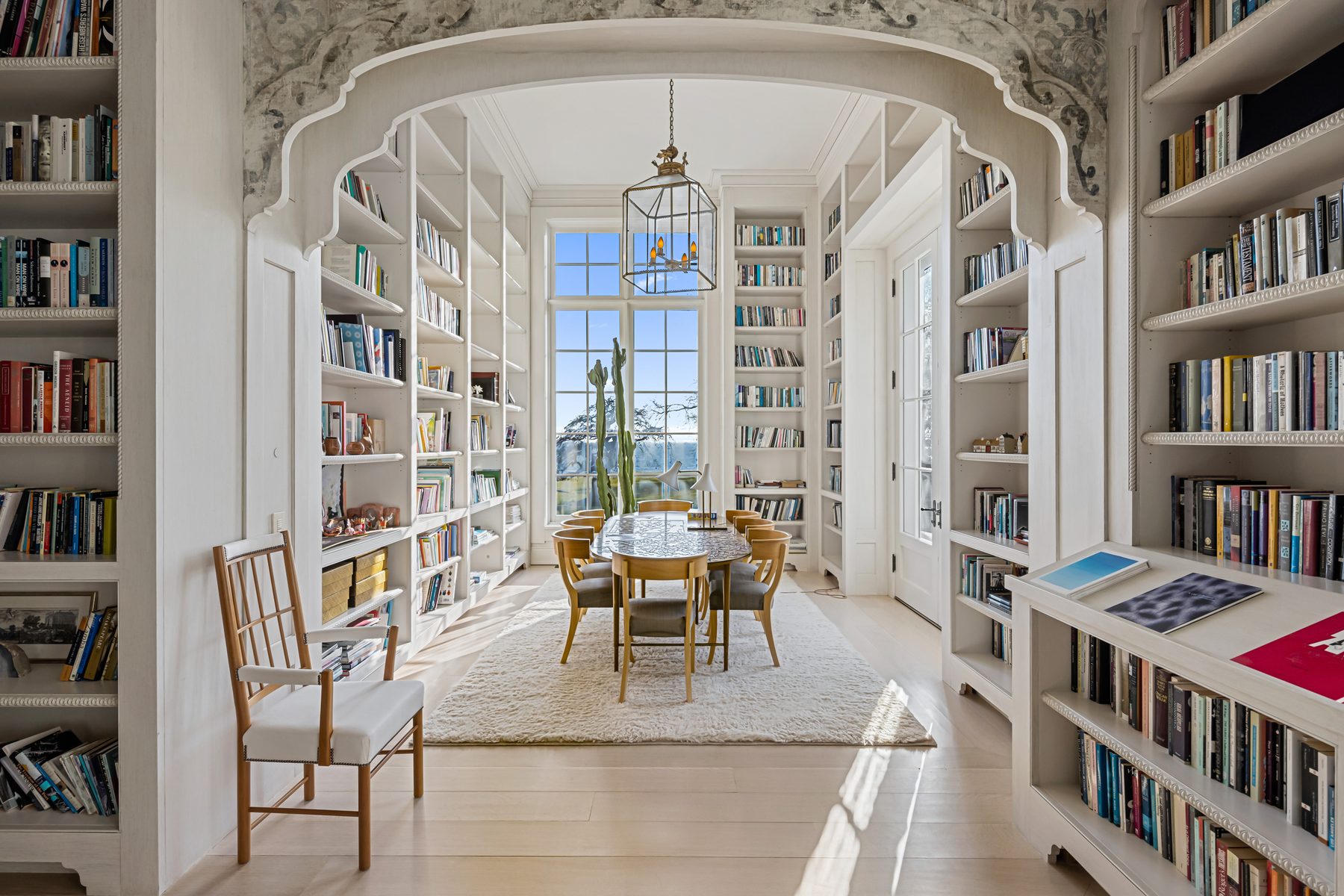 Book-lined library with a dining table beneath a lantern pendant in Fairfield, Connecticut